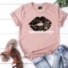 A pink t-shirt with a black and white lip print.