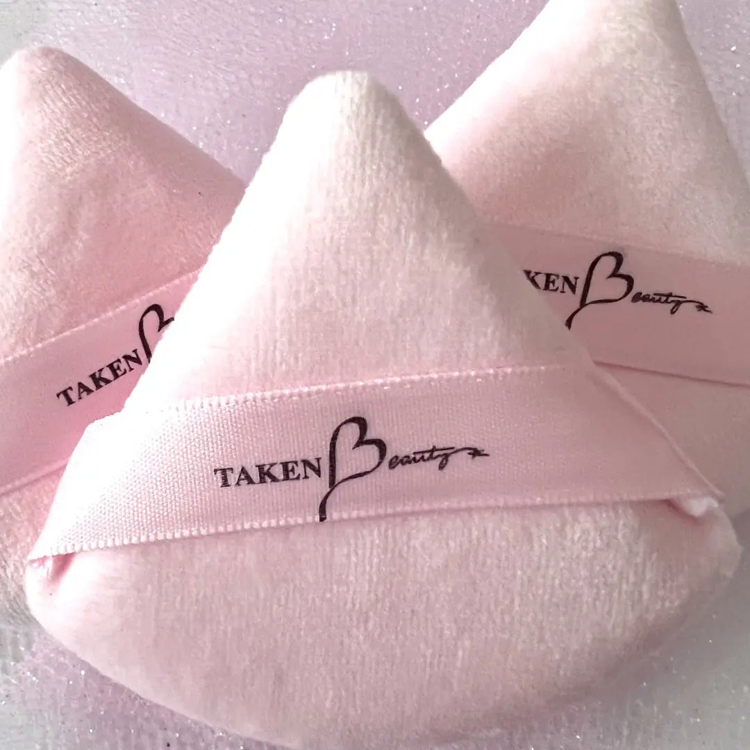 A pair of pink towels with the words taken by design written on them.