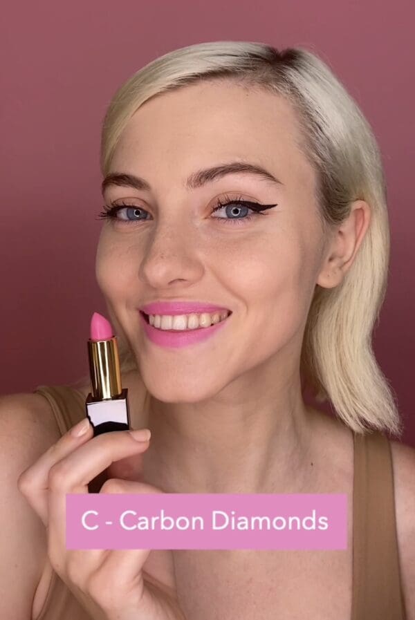 A woman holding a pink lipstick in her hand.