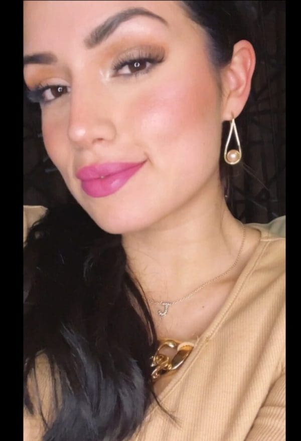 A woman with pink lipstick and a necklace.