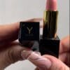 A person holding a lipstick in their hand.