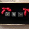 A box with three cubes that say mom.
