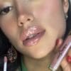 A woman holding onto some lipstick in her hand