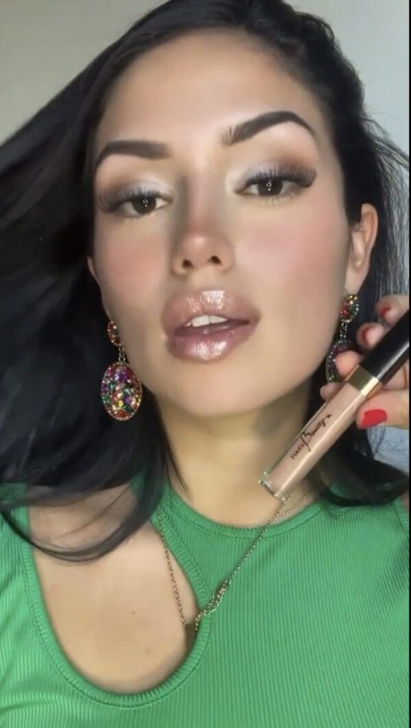 A woman holding a phone and wearing earrings.