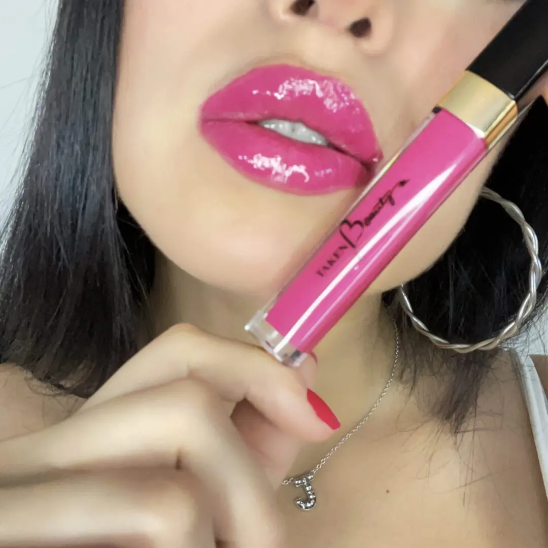A woman holding a pink lipstick in her mouth.