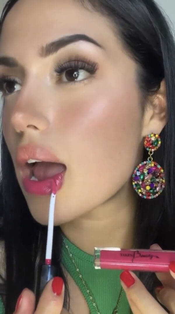 A woman with long black hair and wearing colorful earrings.