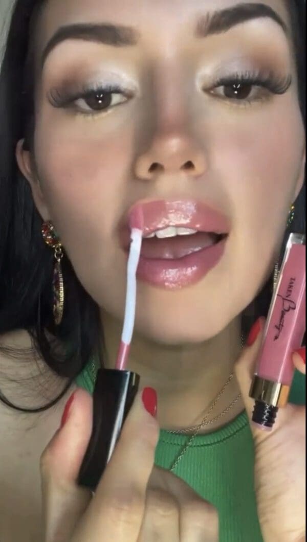 A woman with two lipsticks in her mouth.