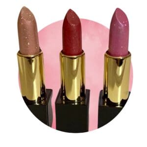 Three different colored lipsticks sitting on top of a pink background.