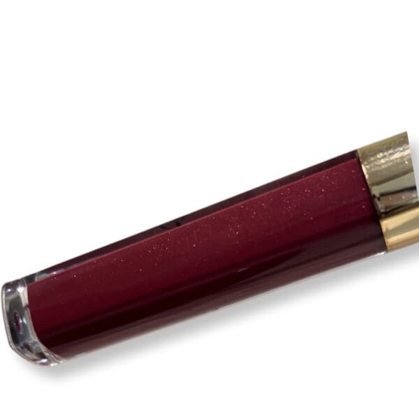 A red lipstick tube with gold trim.