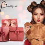 A woman holding a teddy bear and some presents