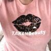 A woman wearing a pink shirt with leopard print lips.