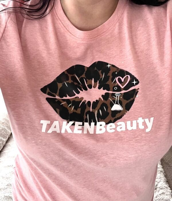A woman wearing a pink shirt with leopard print lips.