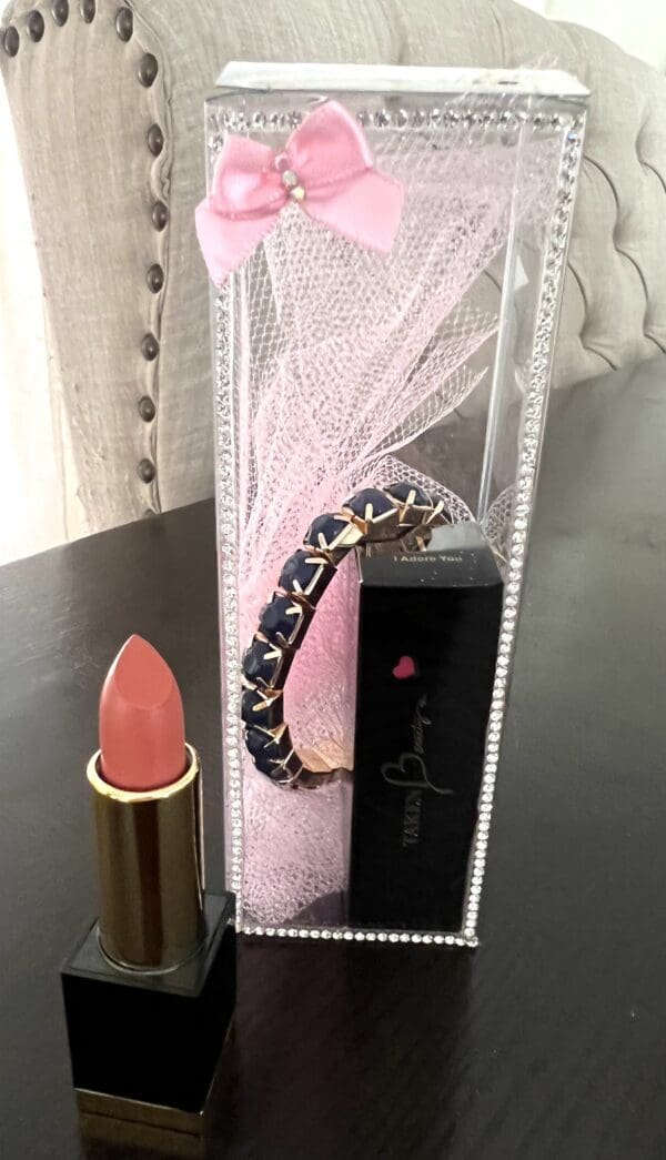 A lipstick and bracelet are on the table.