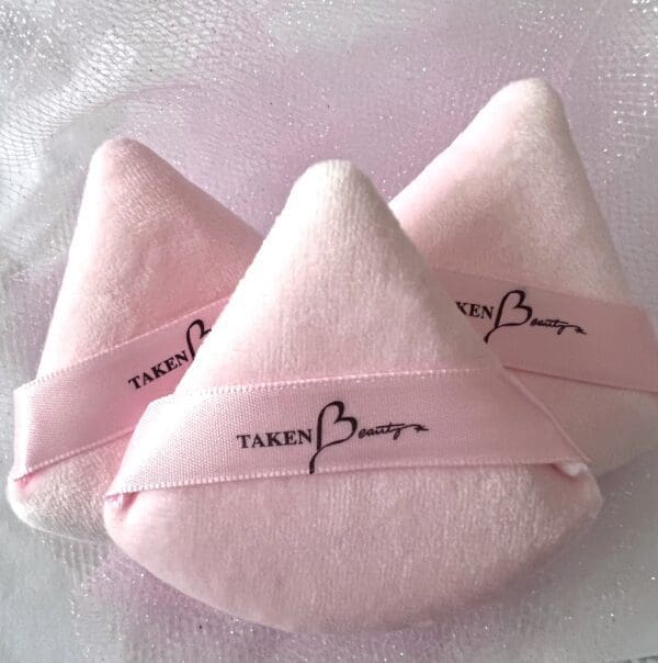 A pair of pink pillows with the words taken by bruno on them.