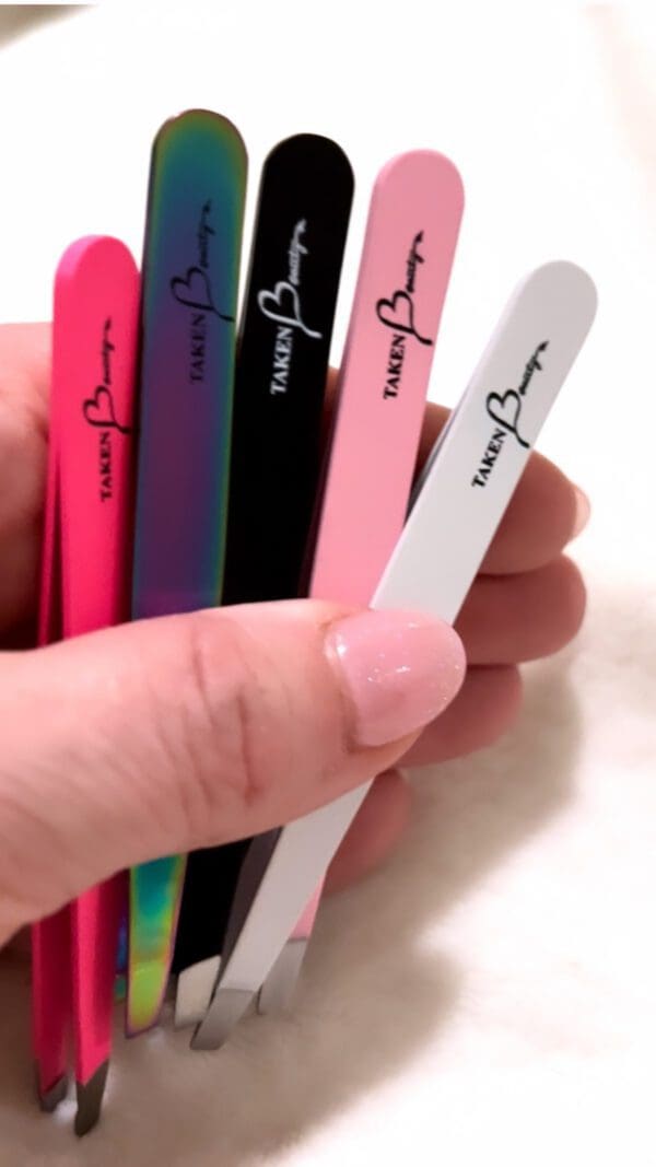 A hand holding some nail files in different colors