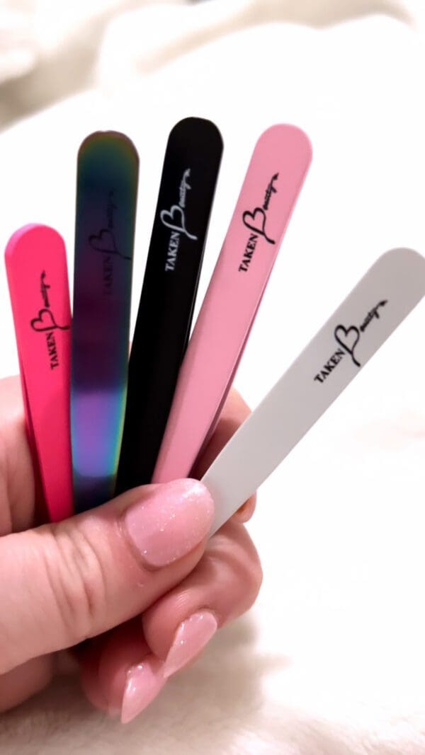 A hand holding some nail files in different colors