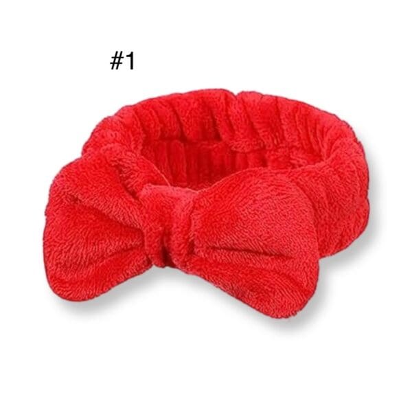 A red bow headband is shown on top of a white background.
