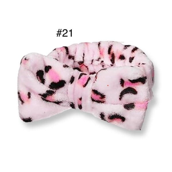 A pink and black leopard print headband is shown.