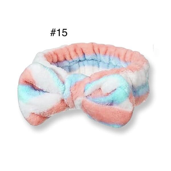 A pink and blue tie dye headband with a bow.