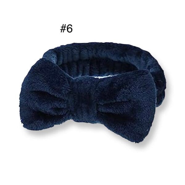 A blue bow tie is laying on top of a white table.