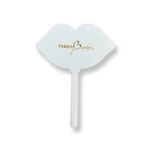 A white plastic hand held fan with the words " fancy lips ".