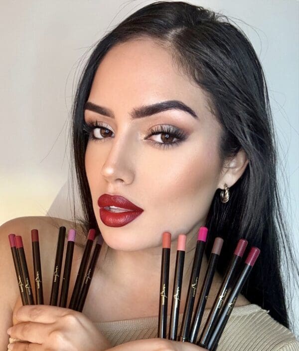A woman holding makeup brushes in her hands.