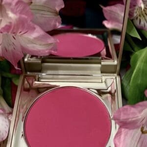 A pink compact with flowers in the background