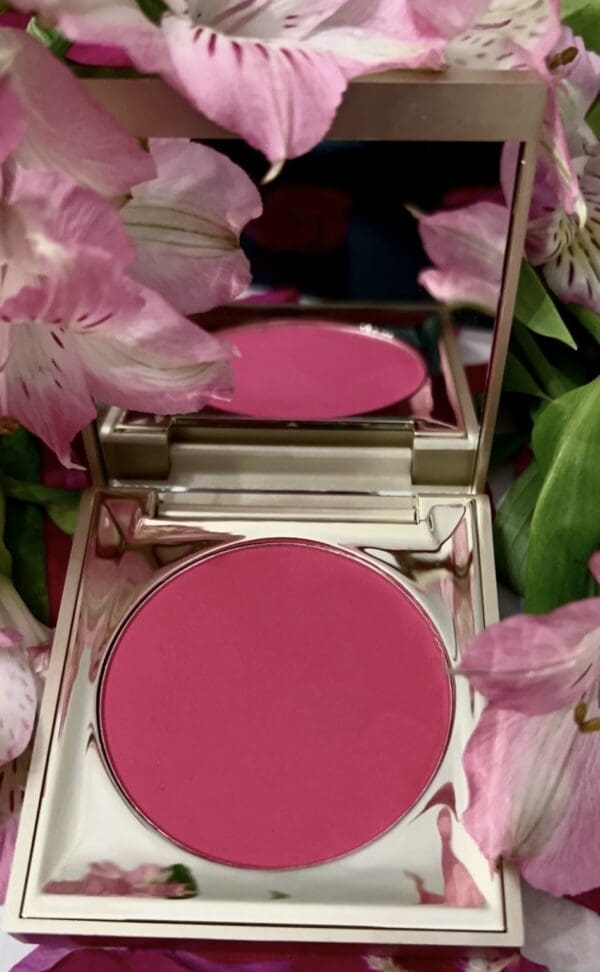 A pink compact with flowers in the background