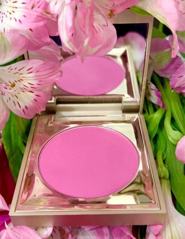 A close up of a pink powder in the mirror