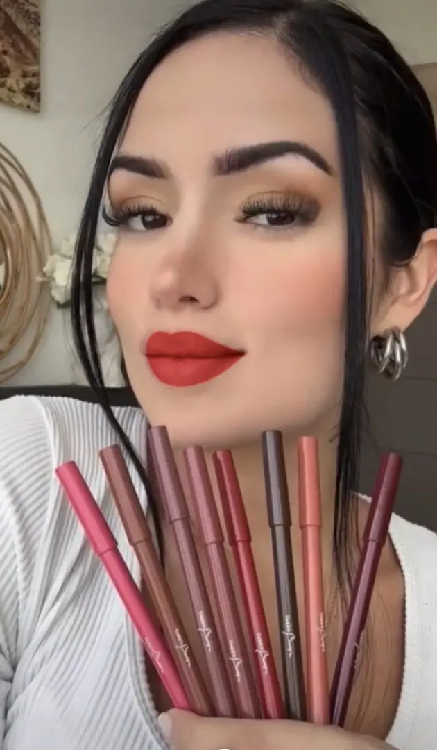 A woman with red lipstick and many lip liners
