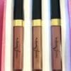 Three lipglosses in a box with black and gold lids.