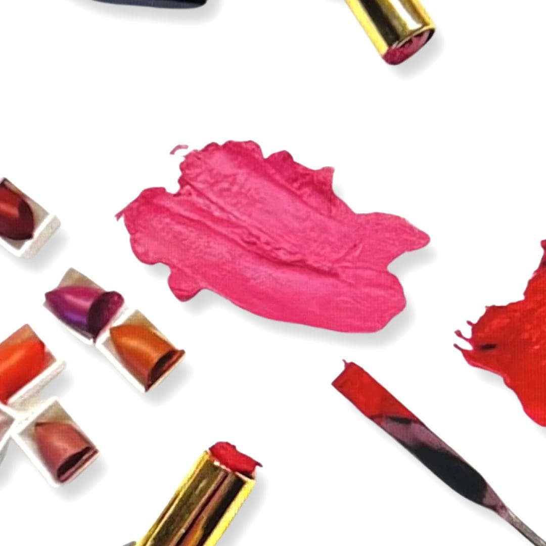 A white table topped with lots of different colored lipstick.