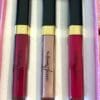 Three lipsticks in a box on top of a table.